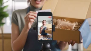 SME owner go green net zero retail store live stream talk on phone showing packaging box